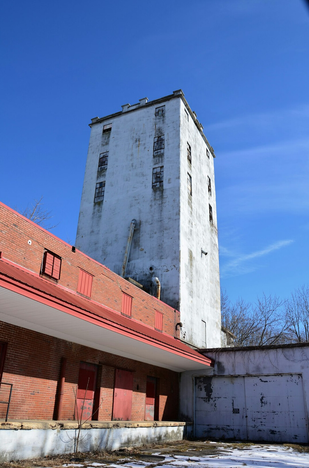 An abandoned grain elevator standing over a small prairie town