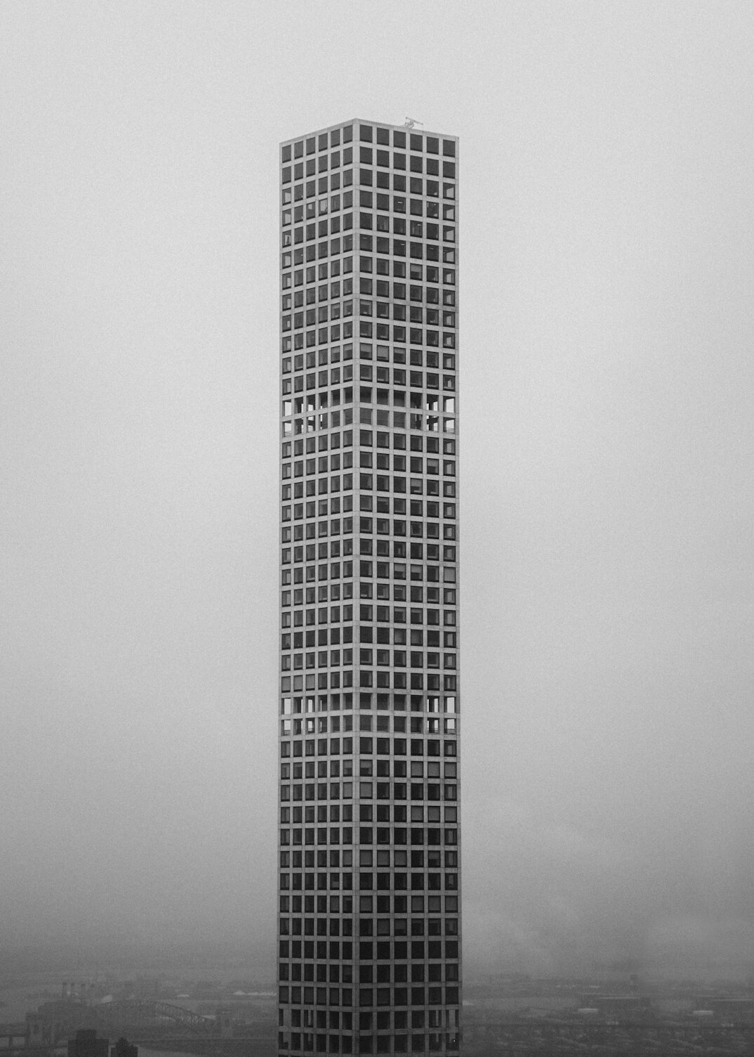 Modernist concrete high rise building against a grey sky